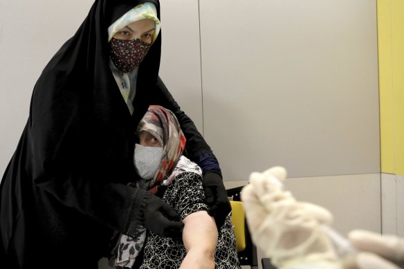 An Iranian woman receives a Sinopharm vaccine for COVID-19 at a shopping centre in Tehran.