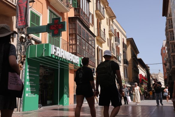 People pass a digital sign indicating a temperature of 42 degrees in Palma de Mallorca, Spain earlier this month.