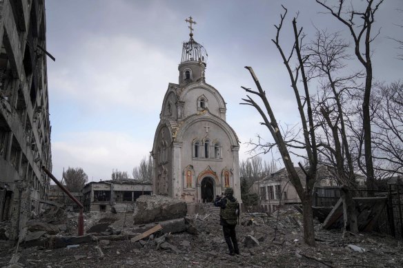 A Ukrainian serviceman takes a photograph of a damaged church after shelling in a residential district in Mariupol, Ukraine. 