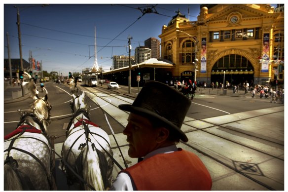 A horse-drawn carriage passes Flinders Street Station.