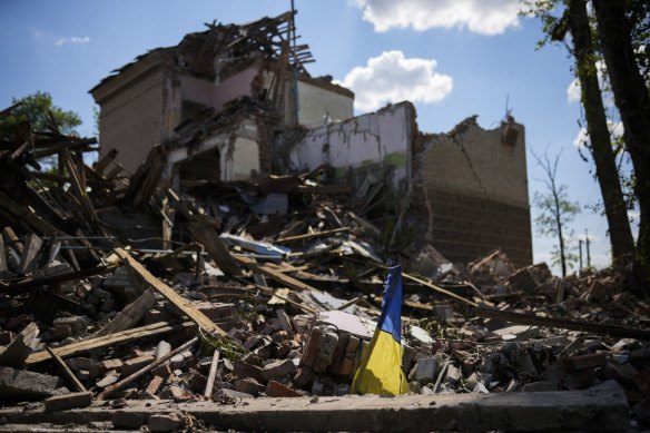 A torn Ukraine flag waves among debris in a school destroyed in a Russian bombing in Bakhmut.
