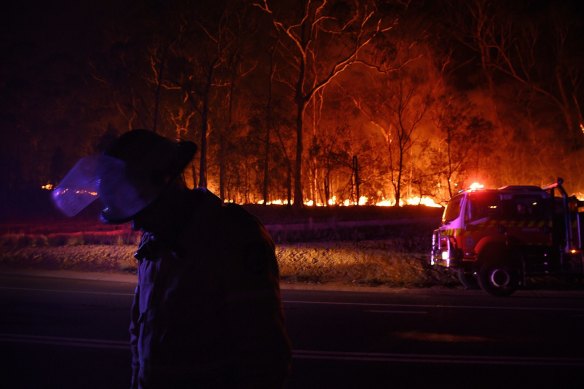 A RFS fire fighter with the Charmhaven unit monitors a small flare up on New Years Day.