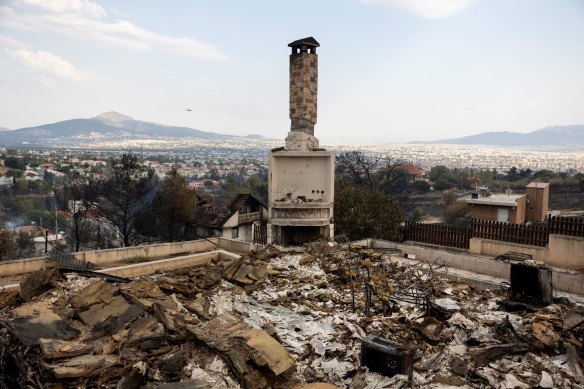 Burnt metal and rubble remain from a house destroyed in Acharnais suburb, north-east of Athens, on Wednesday.