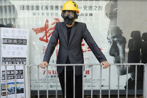 A lawyer wearing a helmet and face mask stands during a protest march in Hong Kong on Wednesday.