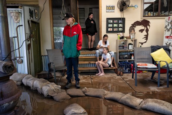 Friends and family of Dick Sharkey help protect his Forbes home from flooding. 