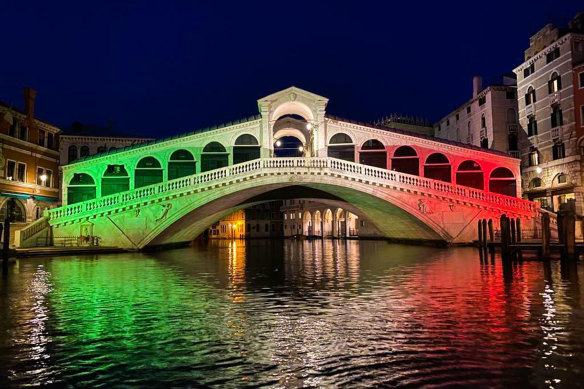 Venice's famous Rialto Bridge is lit in the colours of the Italian flag.