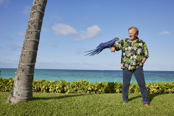 John Singleton at his Oahu home in 2021 with a local macaw, his favorite breed of bird.