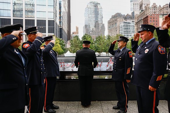 New York City Fire Department (FDNY) members visit the memorial ahead of the ceremony.