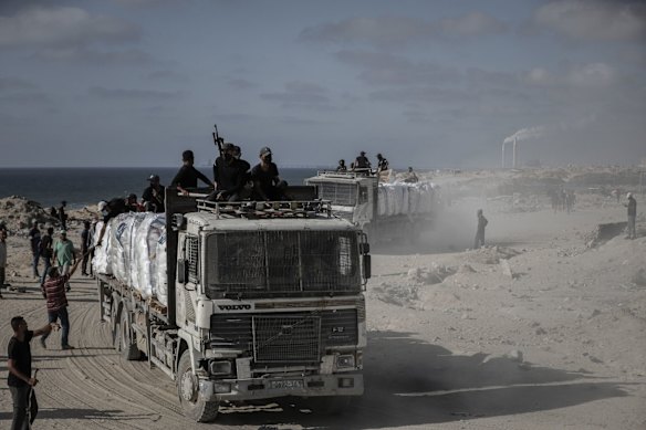 Security guards ride aboard trucks carrying humanitarian aid in Beit Lahia, northern Gaza, on Wednesday.