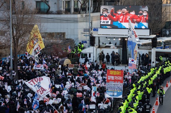 Police officers stand guard as supporters of South Korean President Yoon Suk Yeol gather near the presidential residence.