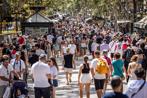 Tourists walk along Las Ramblas in Barcelona.