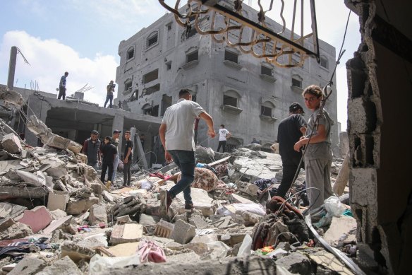 Palestinians amongst the rubble of destroyed buildings following an Israeli airstrike in a residential neighborhood at the Nuseirat refugee camp in central Gaza.