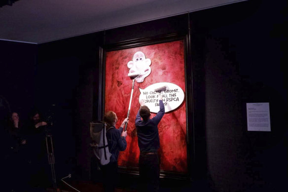 Activists paste a picture of Wallace over the portrait of King Charles III at the Philip Mould Gallery in London.
