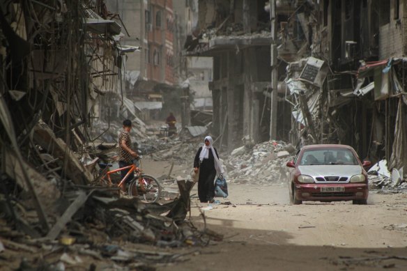Palestinians on a road lined with destroyed buildings in Khan Younis, southern Gaza, on Friday.