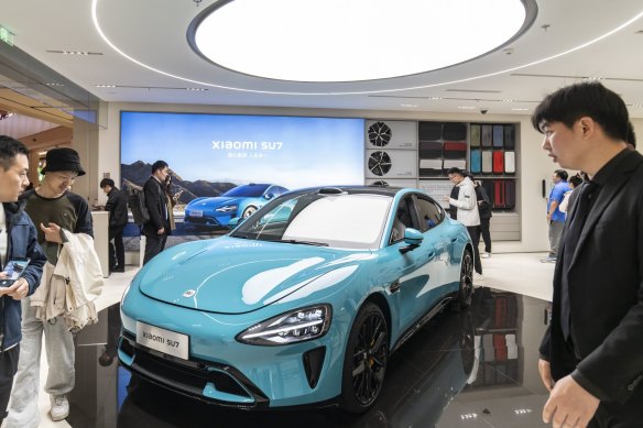 Um veículo elétrico Xiaomi SU7 em exibição em um showroom de Xangai. É provável que quase metade das vendas de carros na China seja EVs este ano.