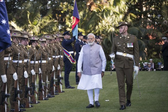 Narendra Modi, India’s prime minister, second right, inspects an honor guard during a welcome ceremony at Admiralty House. 