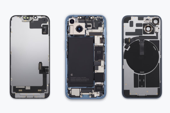 The internal design of the iPhone 14, which can be opened from either side, with most components accessible from the back. If you’re imagining putting the phone back together from this image, the display (on the left) would go under the central structure, with the back glass (right) flipping over and going on top.