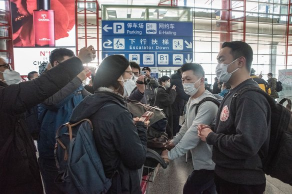 Passengers arriving from overseas are interviewed by the media, on the first day quarantine requirements are officially lifted for international arrivals, at Beijing Capital Airport.