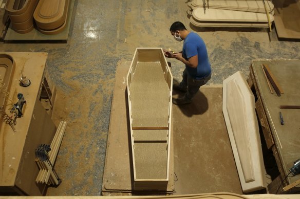 An employee works with a coffin at the Adean coffin-making factory in Spain.