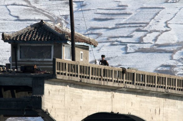 A North Korean soldier looks across the border with China.