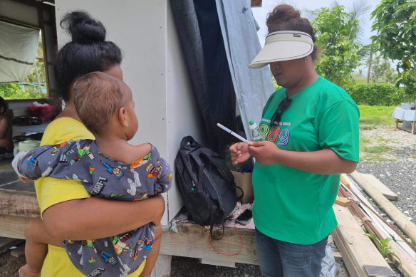 Tuvalu Family Health Association talk to a mother about cervical screening.