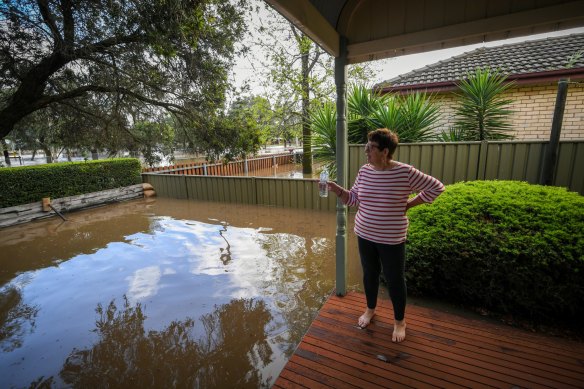 Glenys takes a moment to check on the rising water levels outside.