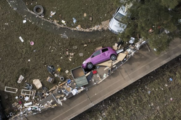 Cars are crushed against the fence at W.Tresise Railway Park in Lismore. Homes and business have been devastated by fast moving flood waters. Access to the area, and the cleanup, has just begun.