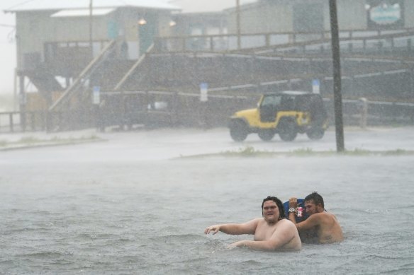 The relative calm before the storm: People play in a flooded parking lot at Navarre Beach in Florida.