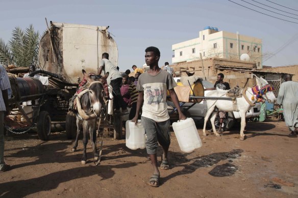 People gather to collect water in Khartoum, Sudan, last year. The Sudanese army and a rival paramilitary force have been battling for control of the country since mid-April.