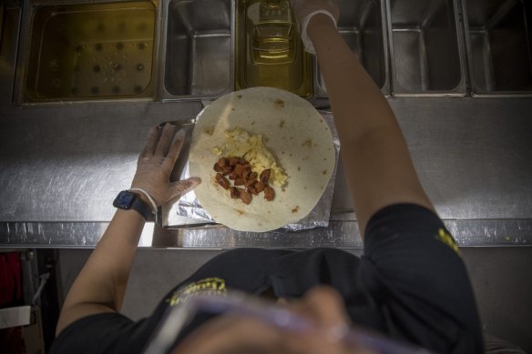 A breakfast burrito being  prepared at a Guzman y Gomez store.