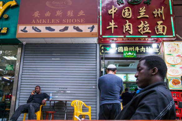Men sit in front of a restaurant off Little North Road, part of an ethnically diverse quarter in Guangzhou known as Little Africa.