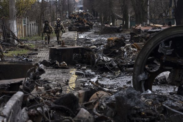 Soldiers walk amid destroyed Russian tanks in Bucha, outside Kyiv.