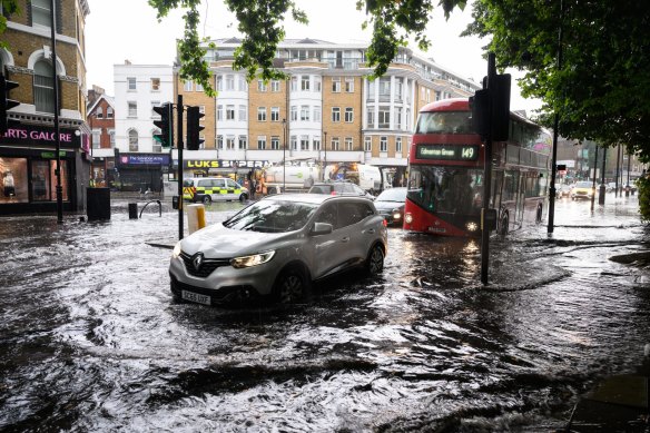 A car negotiates a flooded section of road, as torrential rain and thunderstorms hit London this month.