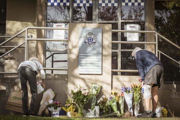 Flowers are placed at a makeshift memorial at Boroondara Police Station in memory of the officers killed.