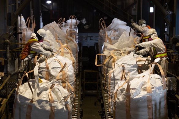 Workers tie bags of copper concentrate in the bagging plant at the Oyu Tolgoi copper-gold mine.