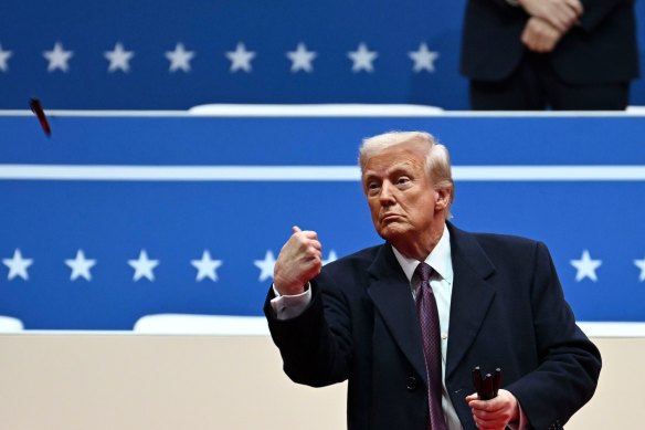 Donald Trump tosses his Sharpie into the crowd after signing executive orders during his inauguration parade.
