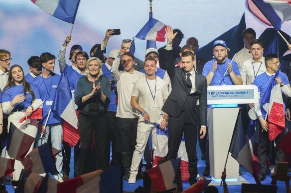 Le Pen and Jordan Bardella (in suit), the president of the National Rally, have attracted the support of younger voters with no memory of World War II.