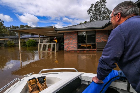 Victor Jones and son Michael evacuate Victor’s brother-in-law, Rob Ives, from his home next to the river. 