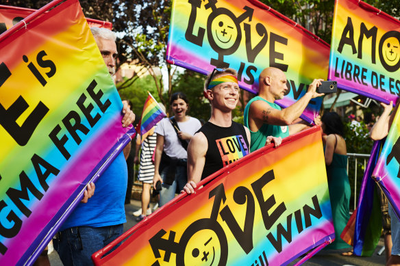 Attendees hold signs during a Stonewall Inn 50th anniversary commemoration rally in New York in June during WorldPride.