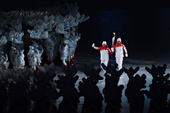 China’s torch bearers Dinigeer Yilamujiang, a Uighur, left, and Jiawen Zhao hold the Olympic flame during the Beijing 2022 opening ceremony.