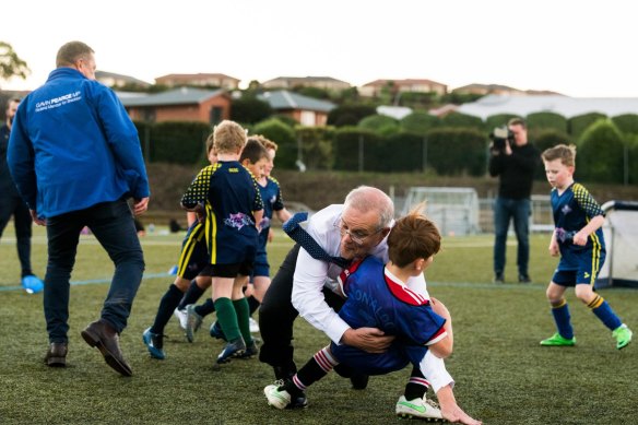 Scott Morrison accidentally takes down Luca Fauvette at a soccer club in Devonport on May 18.