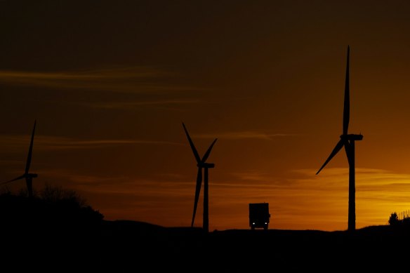 A truck passes a wind farm near Del Rio, Texas, Wednesday, Feb. 15, 2023. 