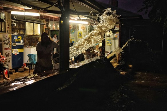 Water is hurled from a Forbes home as locals battle to fight flooding. 