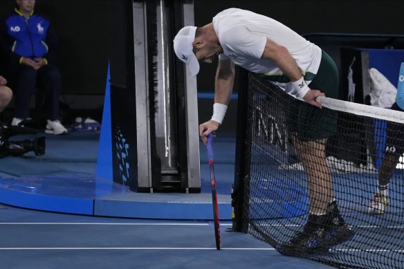 Andy Murray of Britain rests on the net during his third round match against Roberto Bautista Agut of Spain.