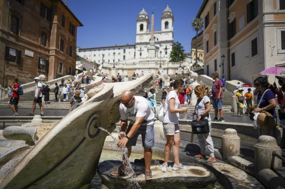 Tourists cool off in the Barcaccia fountain at the foot of the Spanish Steps in Rome.