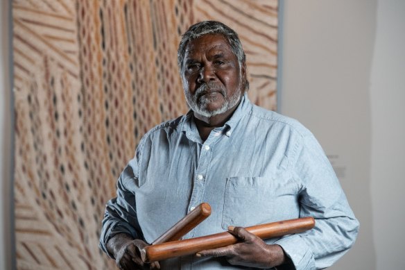 Artist Djambawa Marawili AM from Yilpara, NT, in front of his artwork Journey to America.