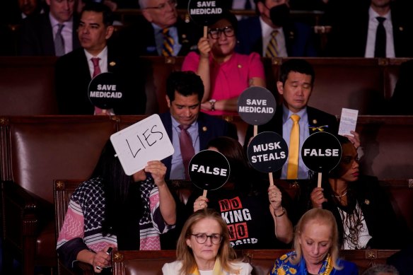 Democrats held up signs in protest of Donald Trump and his agenda.