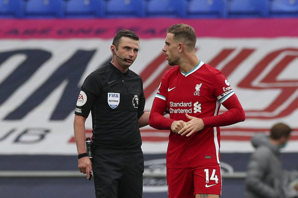 Jordan Henderson speaks to referee Michael Oliver as they wait for the VAR decision that would rule out Henderson's winner.