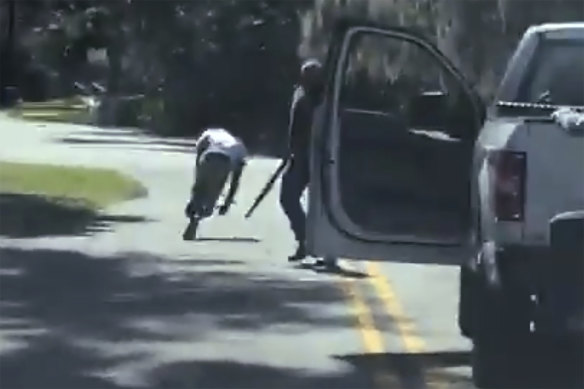 Ahmaud Arbery stumbles and falls to the ground after being shot as Travis McMichael stands by holding a shotgun in a neighbourhood outside Brunswick, Georgia. 