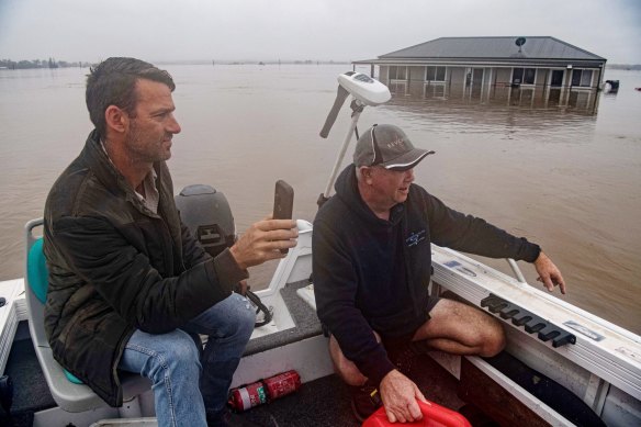 Dan Streat, left, video-calls Mario Fenech from a boat above Mr Fenech’s turf farm.